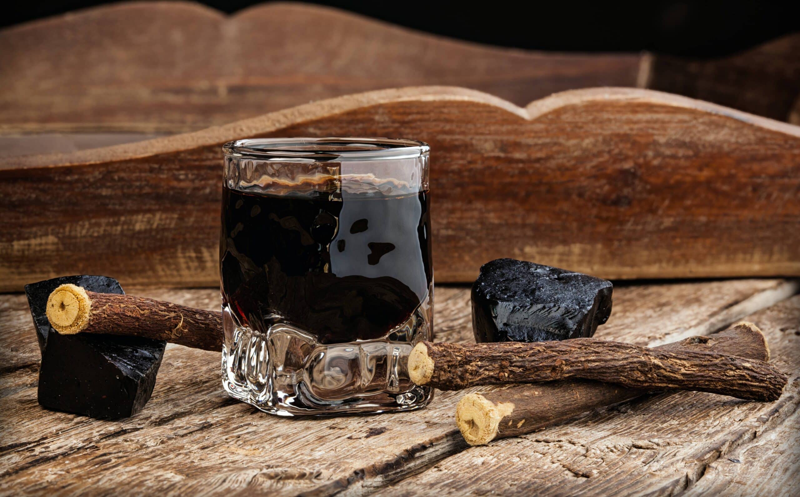 Licorice,Liqueur,With,Pure,Blocks,And,Roots,On,Wooden,Table.